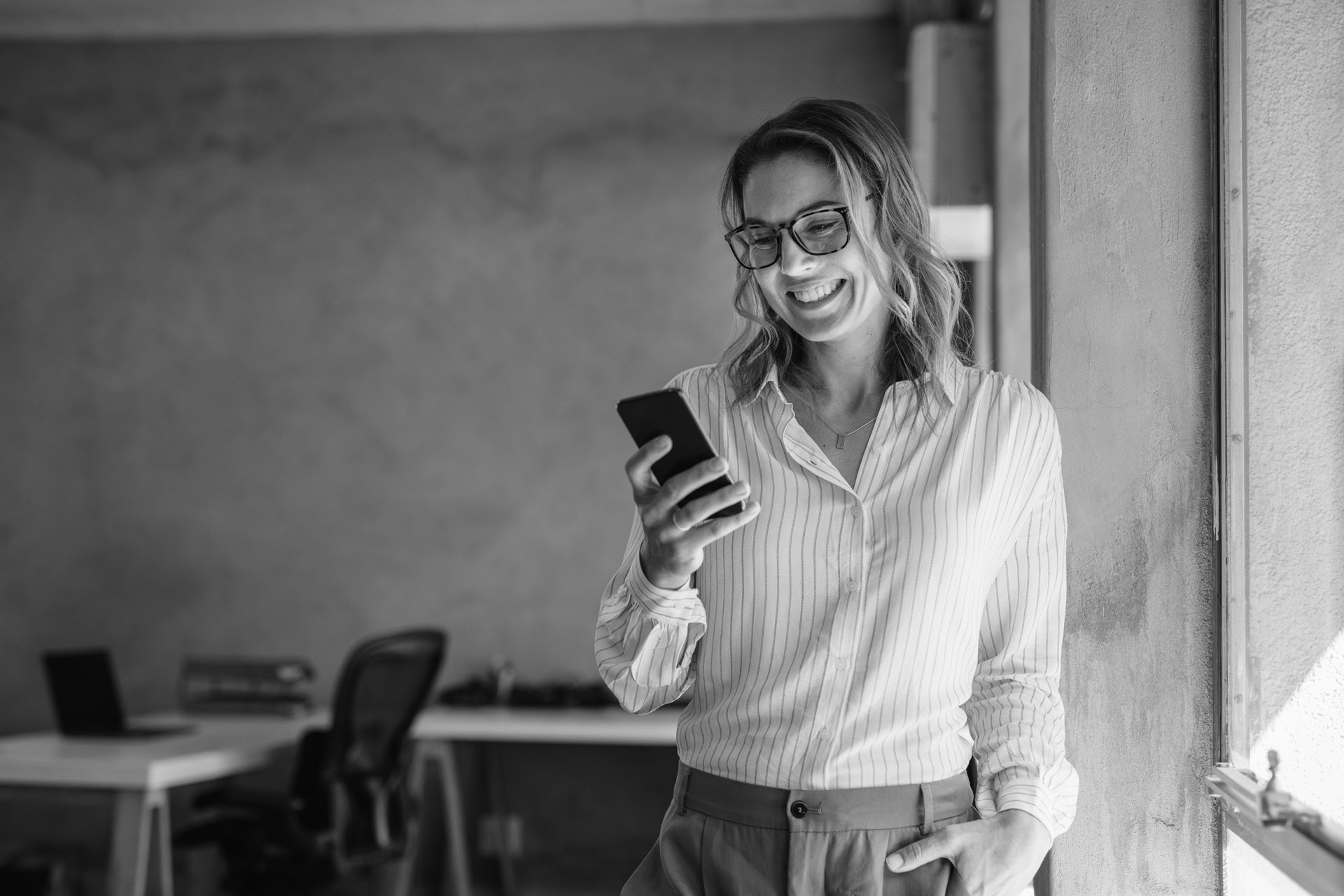 Frau blickt auf Smartphone.
